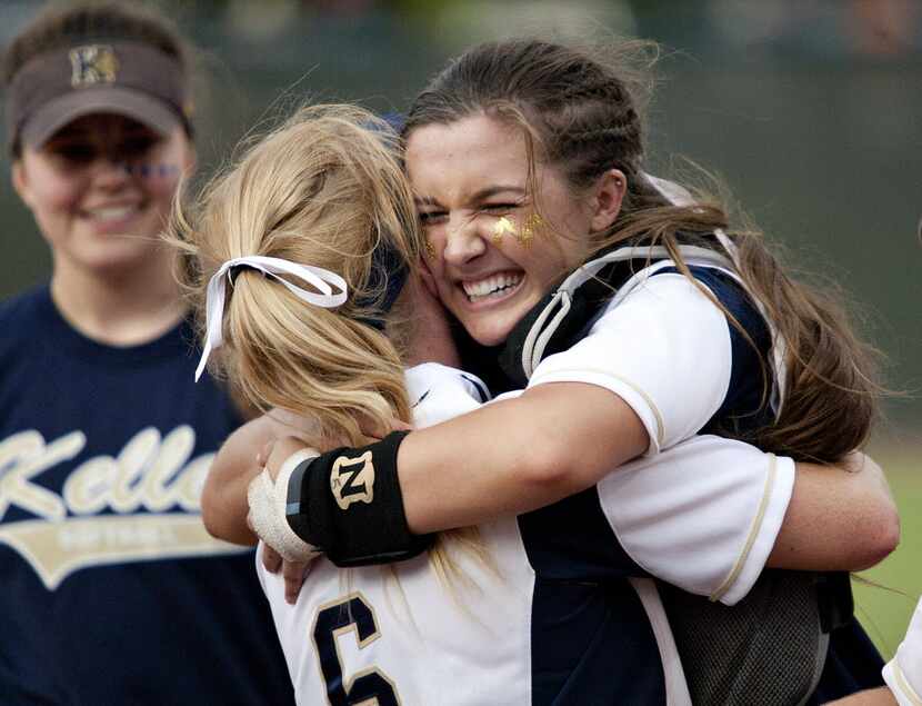 Keller player Kasey Simpson (6, back to camera) hugs teammate Shelby Henderson (5, facing)...