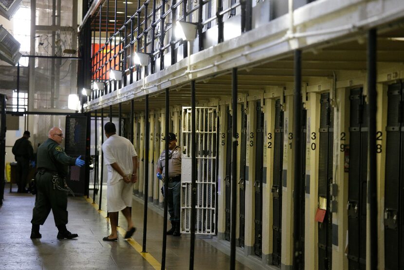 A condemned inmate is led out of his east block cell on death row at San Quentin State...