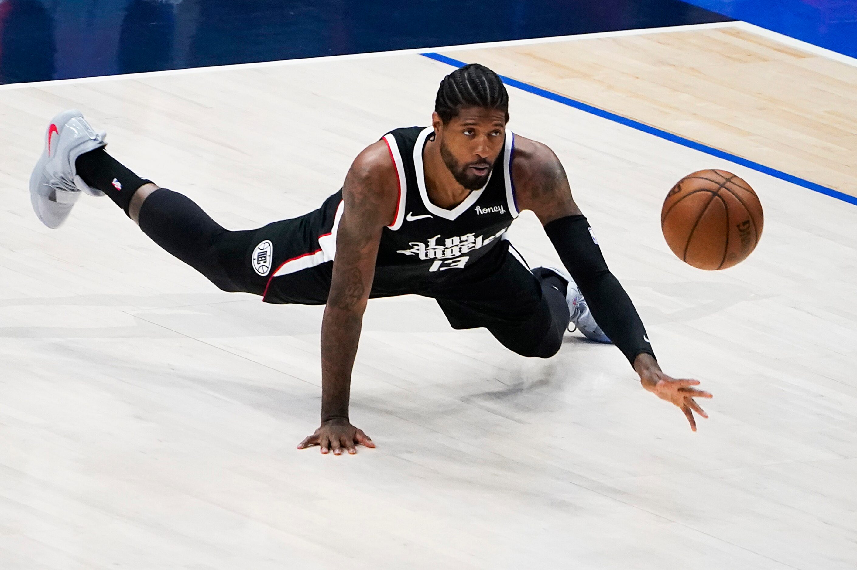 LA Clippers guard Paul George (13) dives for a ball during the first quarter of an NBA...