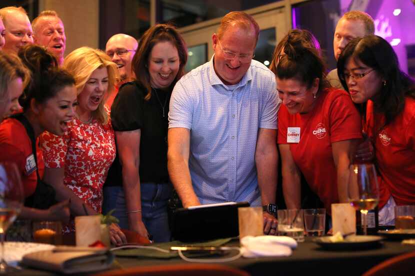 Frisco mayor Jeff Cheney, center, checks the poll numbers with his supporters during a watch...