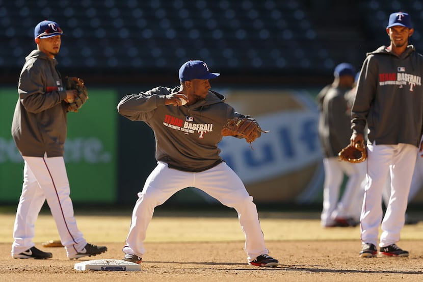 Texas Rangers infielder Jurickson Profar, center, works on his form as he prepares to throw...
