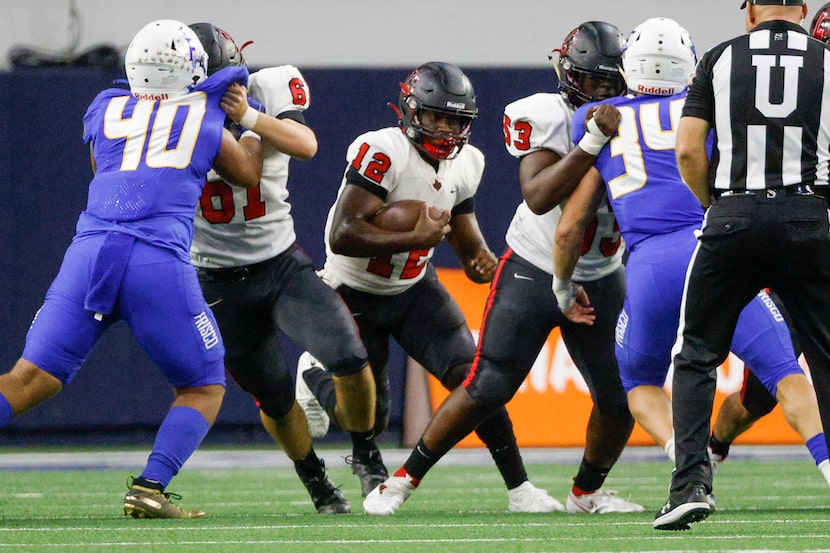 Frisco Liberty quarterback Keldric Luster (12) runs through the line during the first half...