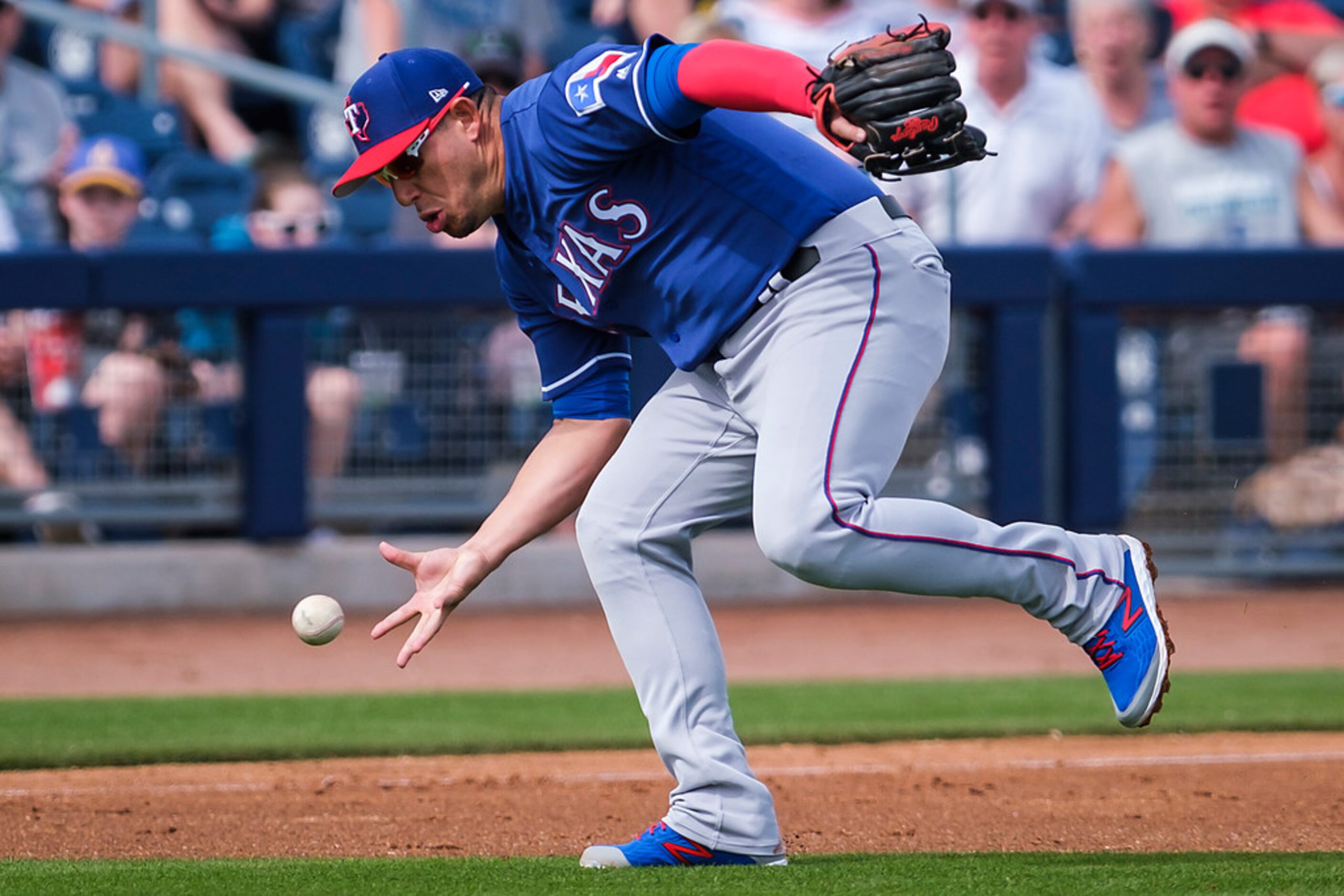 Texas Rangers third baseman Asdrubal Cabrera makes a bare-handed grab on a soft grounder by...