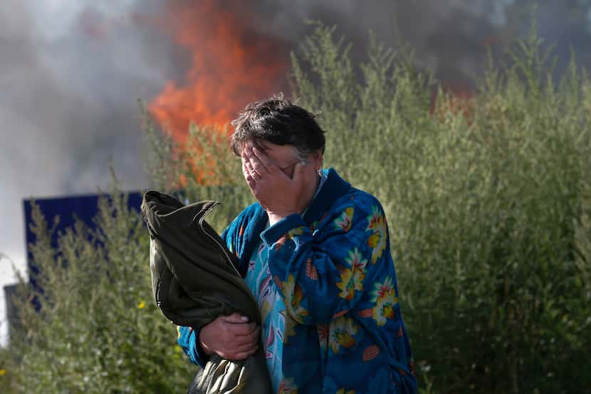 A woman cries near her burning house after shelling in the city of Slovyansk, Donetsk...