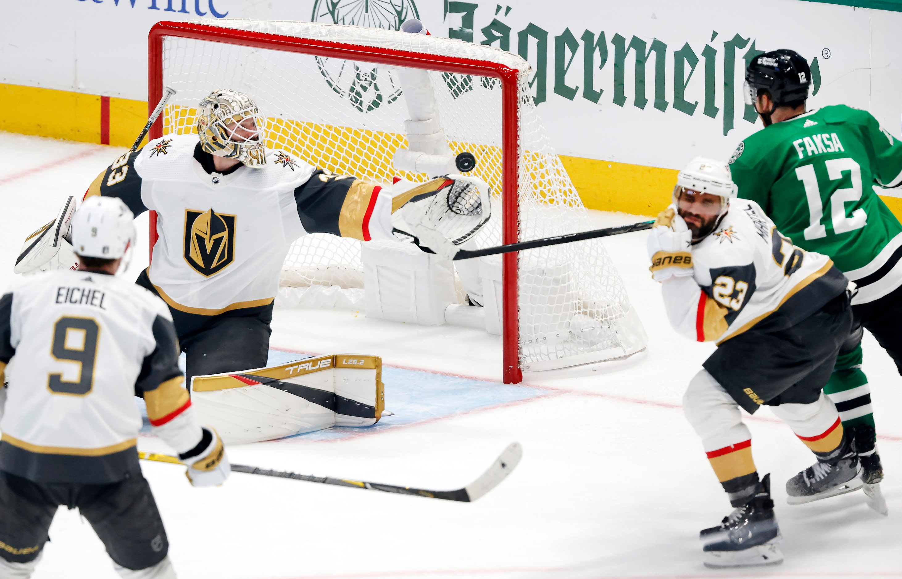 Vegas Golden Knights goaltender Adin Hill (33) swats away a shot by Dallas Stars center...