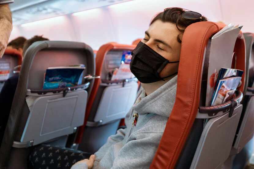 Una persona porta un tapabocas durante un vuelo en un avión.