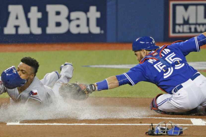 Texas Rangers center fielder Delino DeShields (7) slides home with the first run of the game...