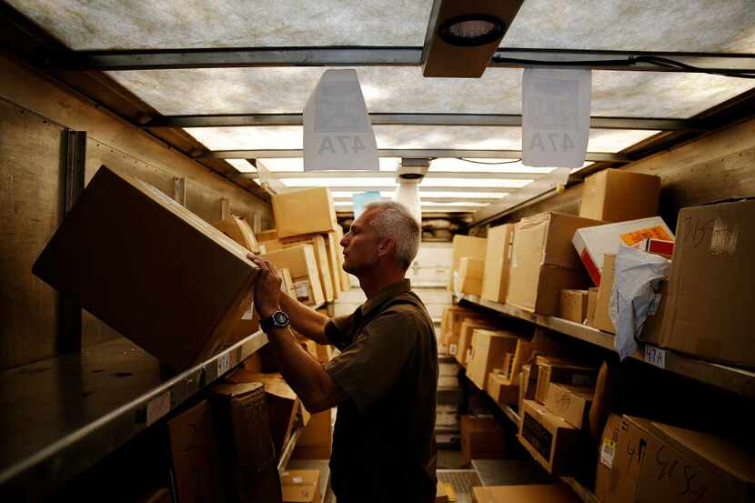  A United Parcel Service driver checks the information on boxes in the back of his truck...