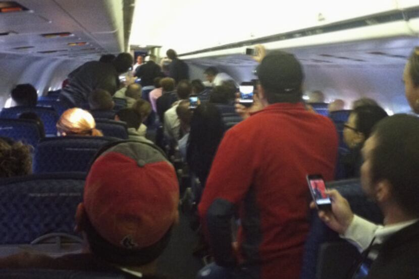A cellphone photo provided by Jessica Mill shows passengers looking toward a disturbance at...