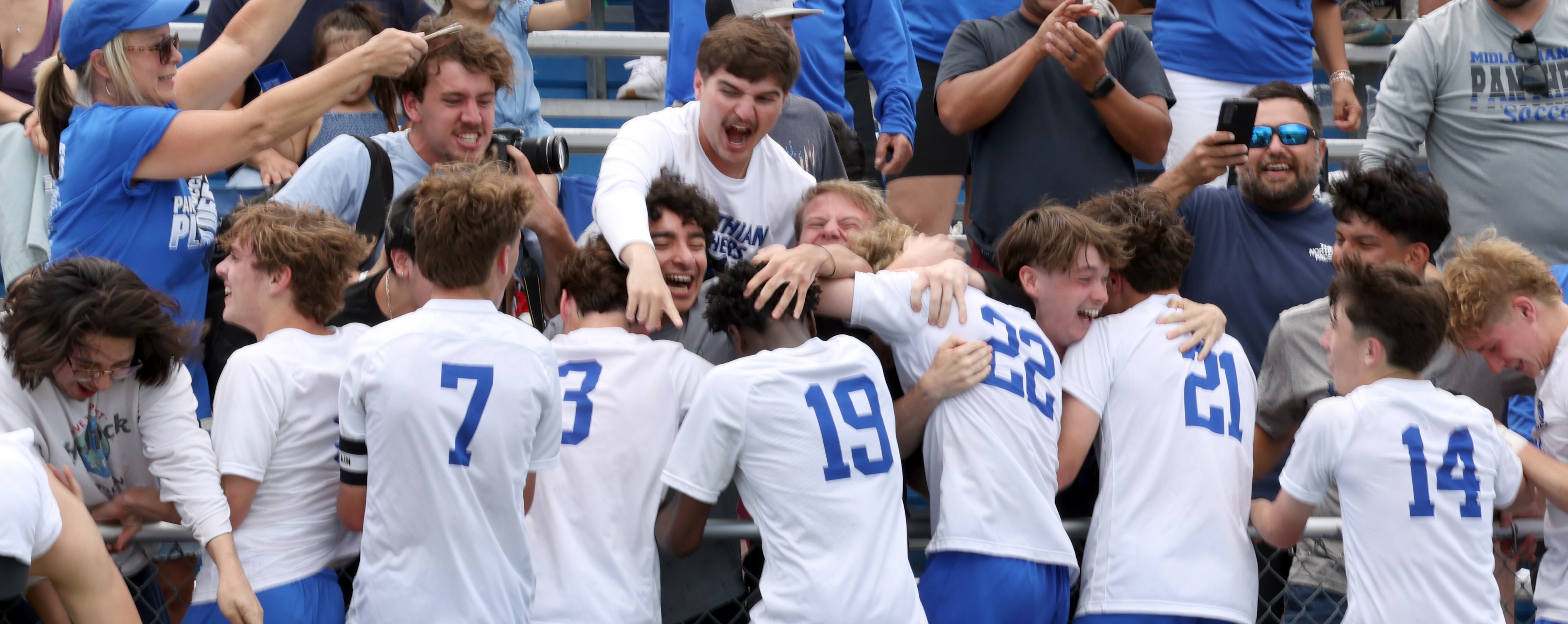 Midlothian fans in the stands share their excitement with players that climbed the fence to...