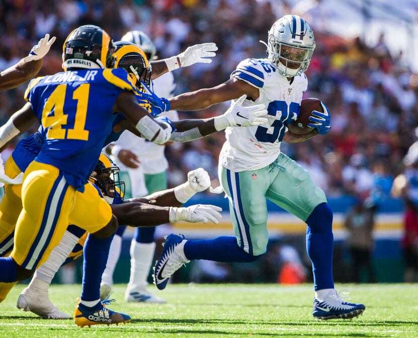 Dallas Cowboys running back Tony Pollard (36) stiff arms Los Angeles Rams defenders during...