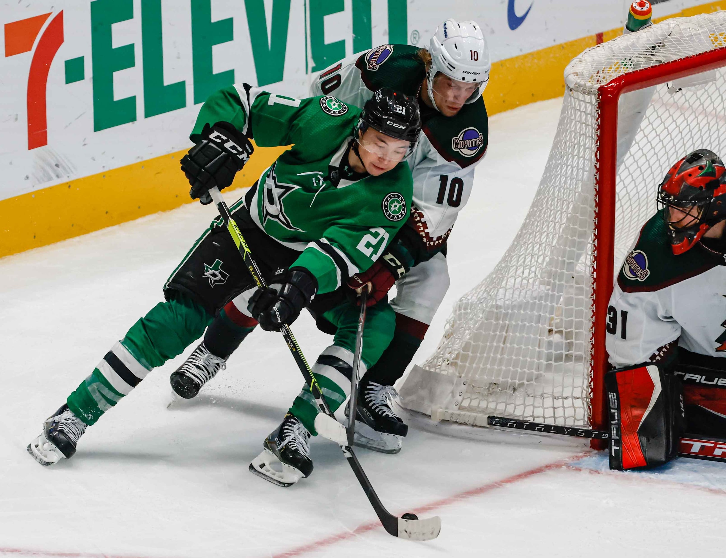 Dallas Stars left wing Jason Robertson (21) goes around Arizona Coyotes center Ryan Dzingel...