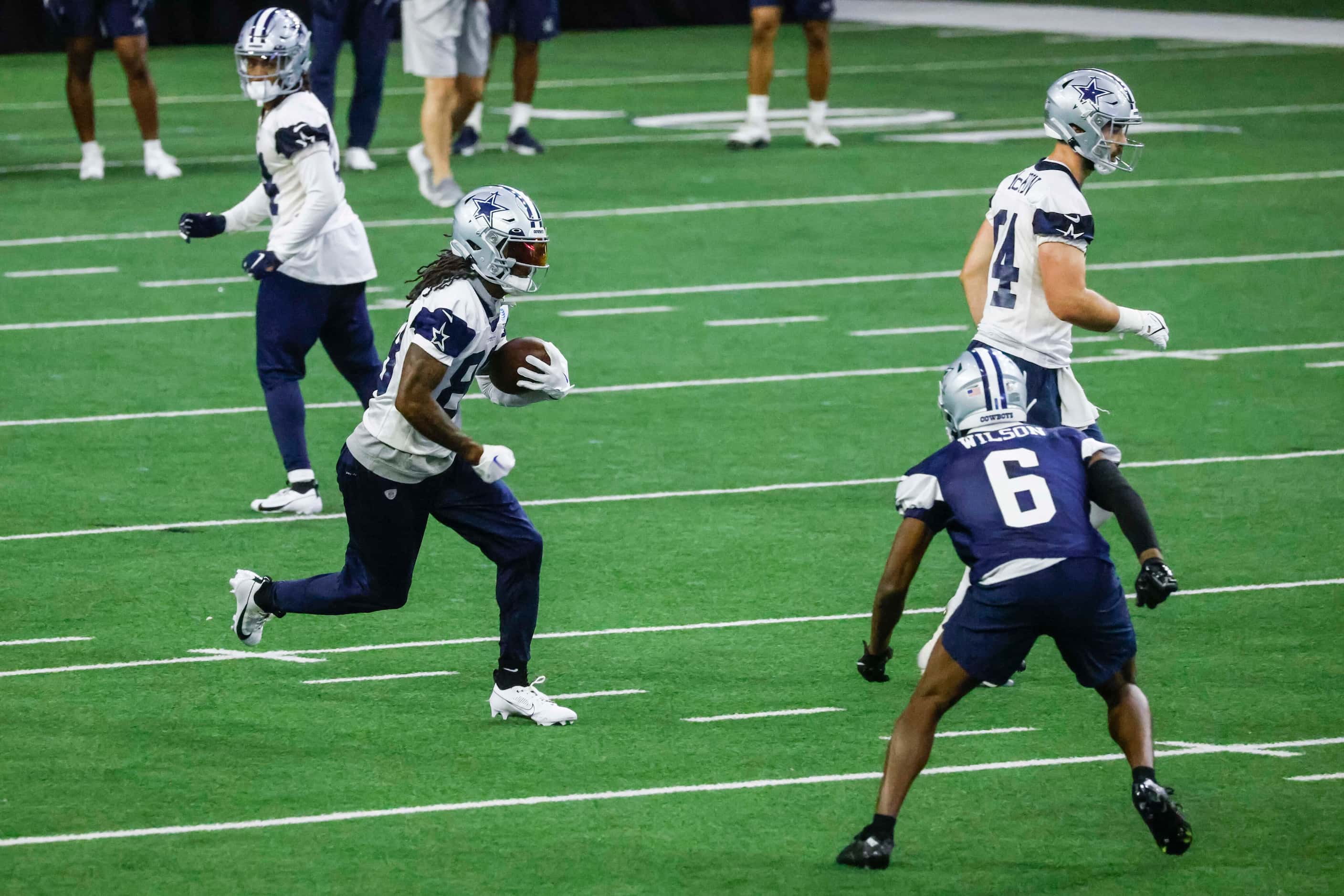 Dallas Cowboys wide receiver CeeDee Lamb (left) runs with the ball during OTA practice on...