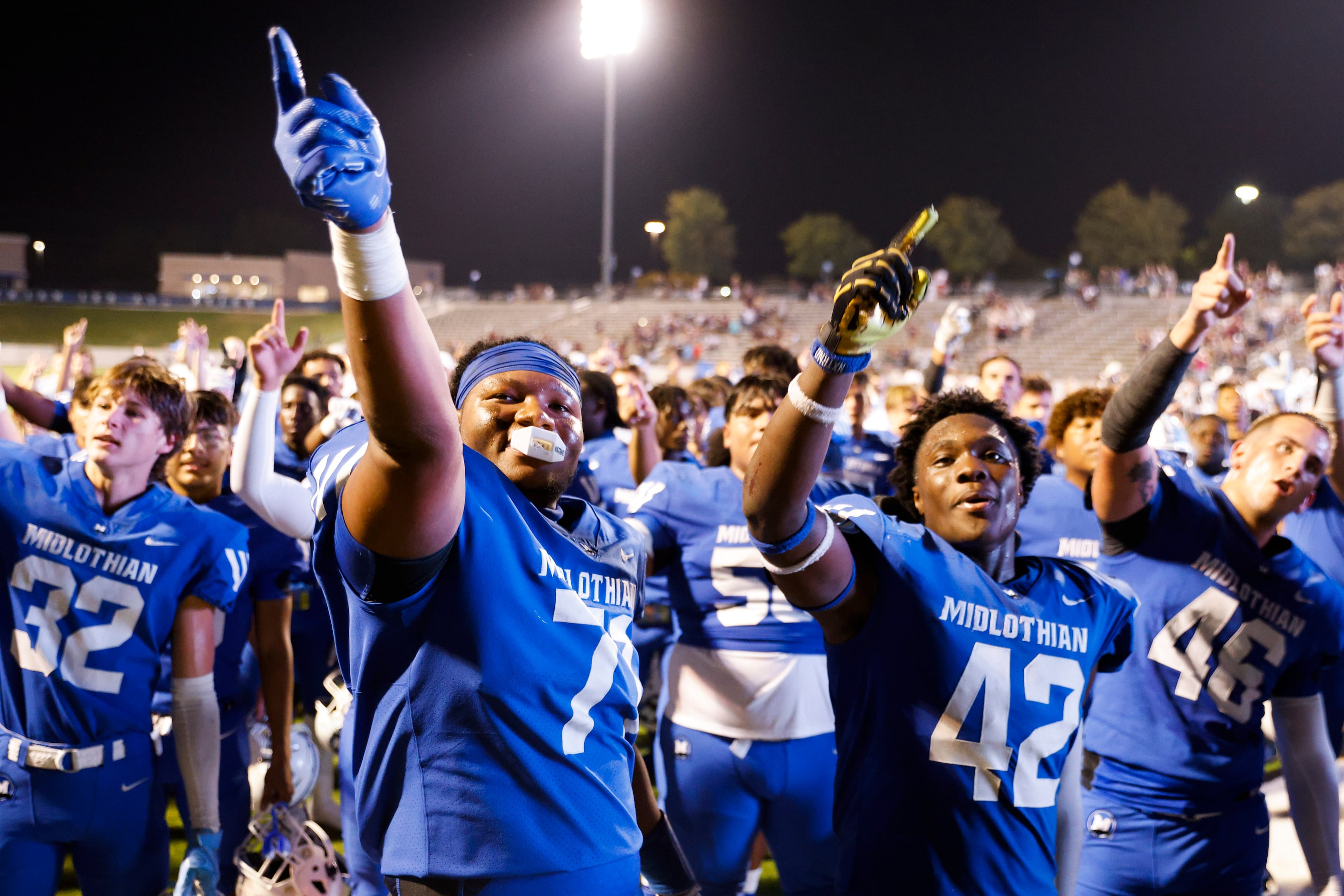 Midlothian high players including Kameron Redmond (left) and Ny’Tori Burnett cheer while...