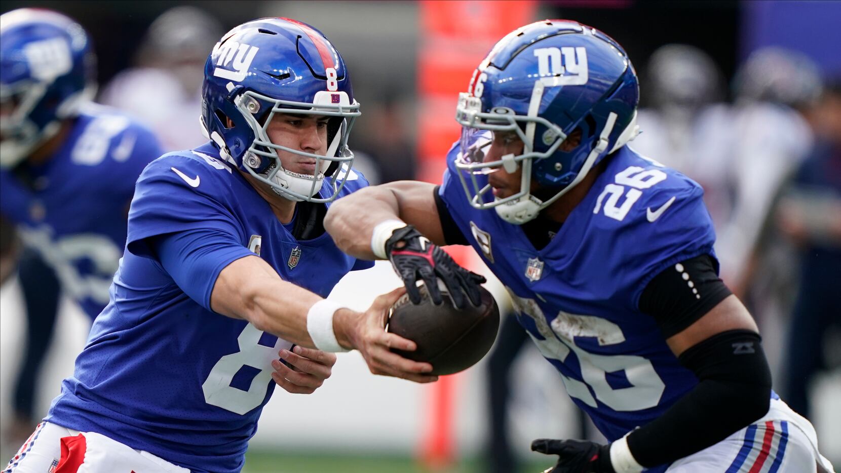 New York Giants quarterback Daniel Jones (8) hands off the ball to New York Giants running...