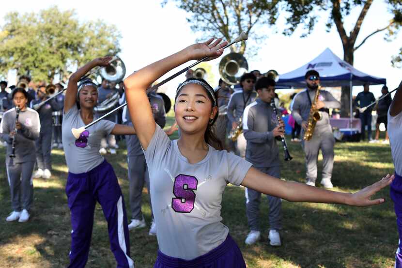 Zahyra Vazquez, 16, twirls as the Sunset High School band cheers on runners during the...