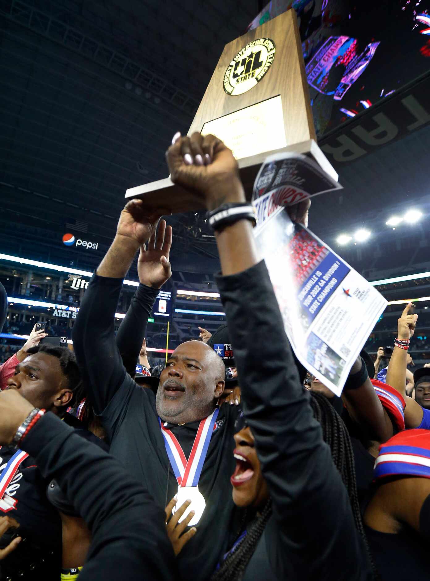 Duncanville head coach Reginald Samples hoists the Class 6A Division I state championship...