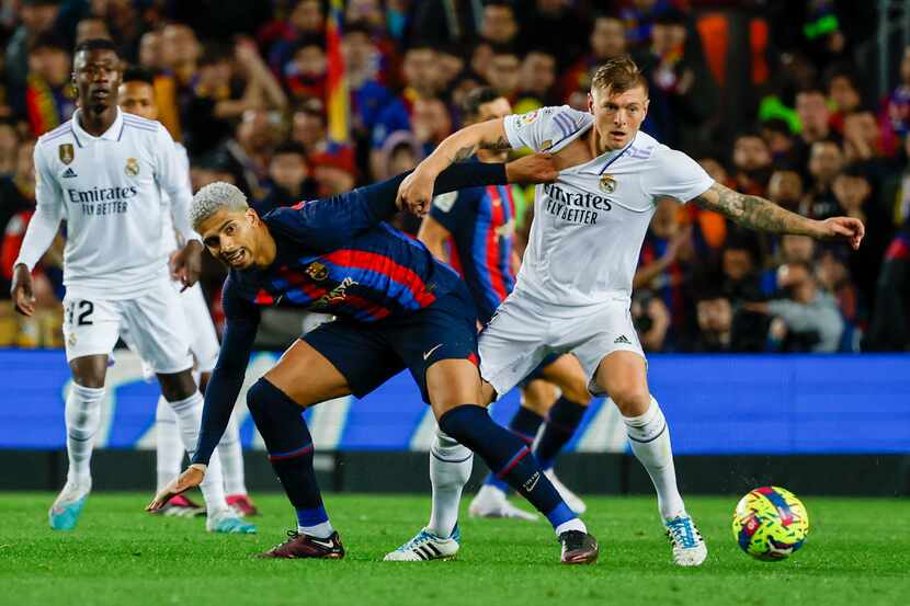 Toni Kroos (derecha) del Real Madrid y Ronald Araujo del Barcelona pugnan por el balón...