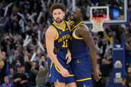 Golden State Warriors guard Klay Thompson, left, is congratulated by forward Draymond Green...