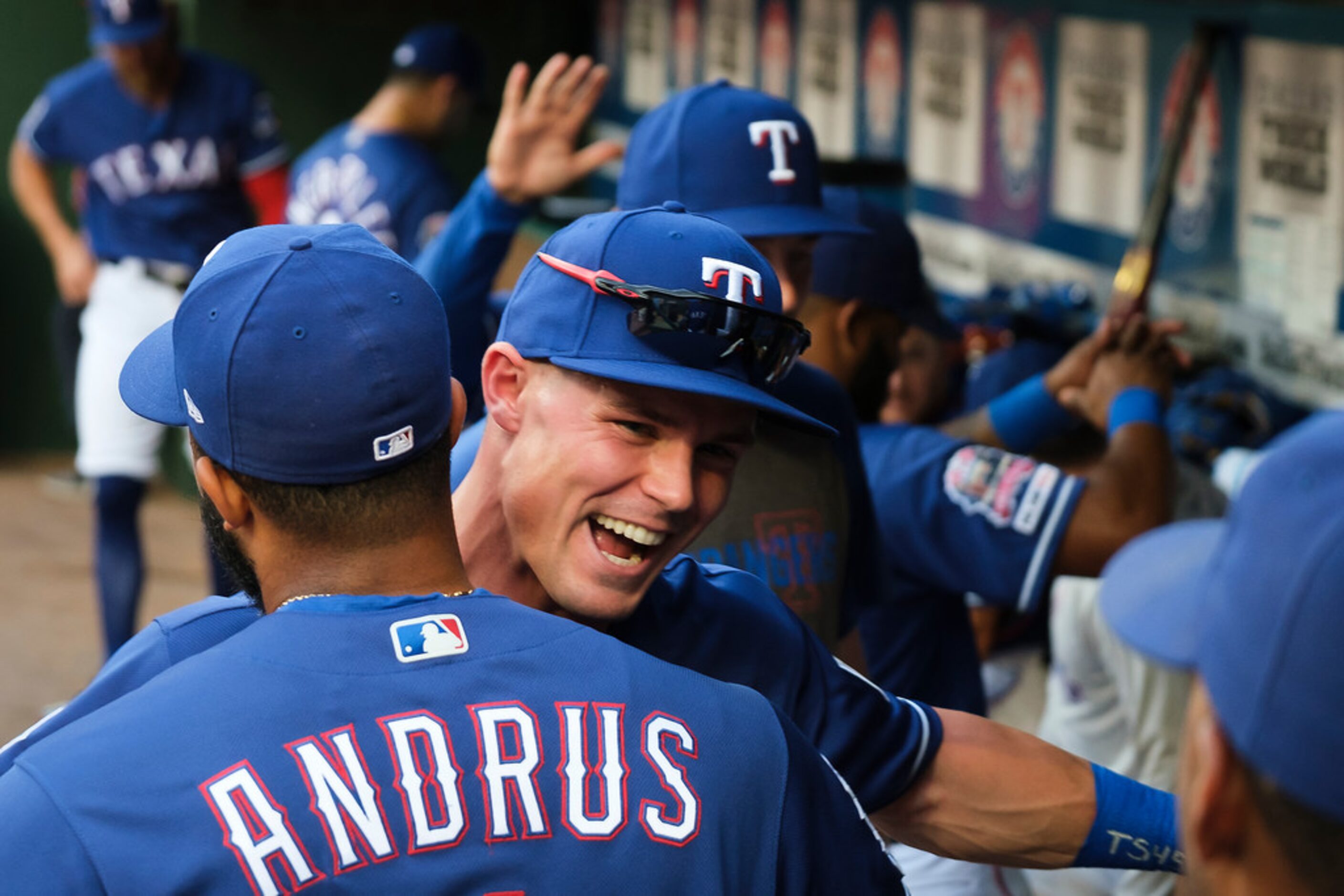 Texas Rangers outfielder Scott Heineman lhugs shortstop Elvis Andrus in the dugout before a...