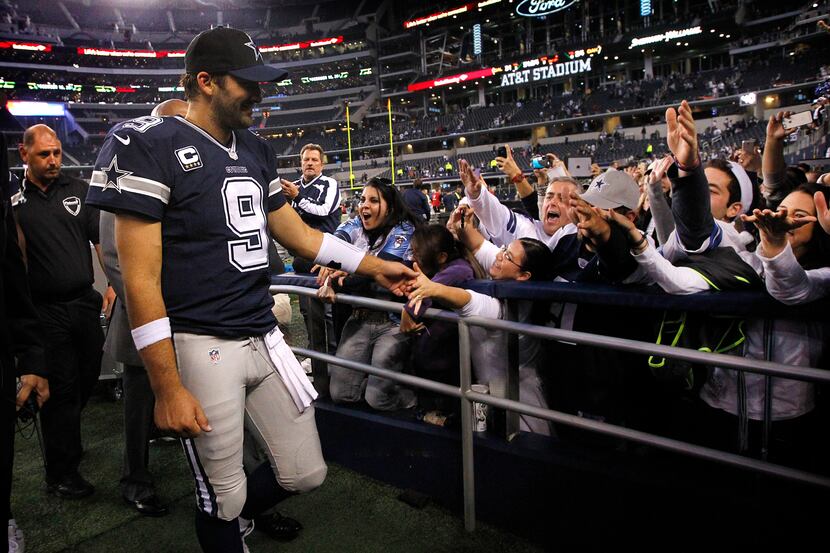 Dallas Cowboys quarterback Tony Romo (9) slaps hands with fans after their win over the...