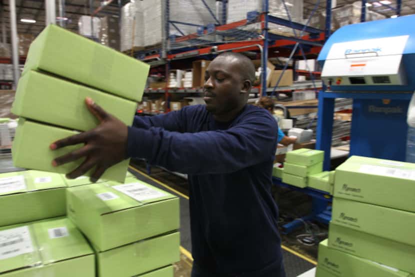 At a warehouse in Coppell, Abiola Gbolagun readies boxes of Mannatech supplements to be...