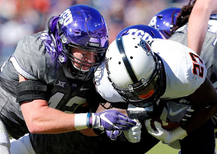 FILE - TCU linebacker Ty Summers (42) puts a hit on Oklahoma State running back Justice Hill...