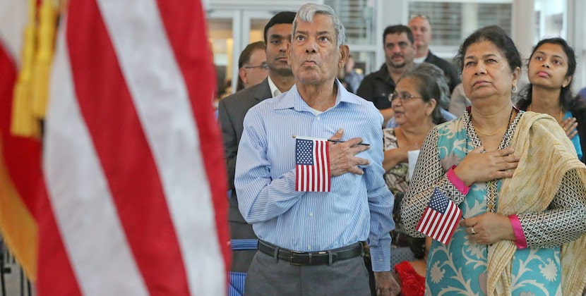 Mohammad Jameel and Shahnaz Parveen, both from Pakistan, listen to the national anthem as...