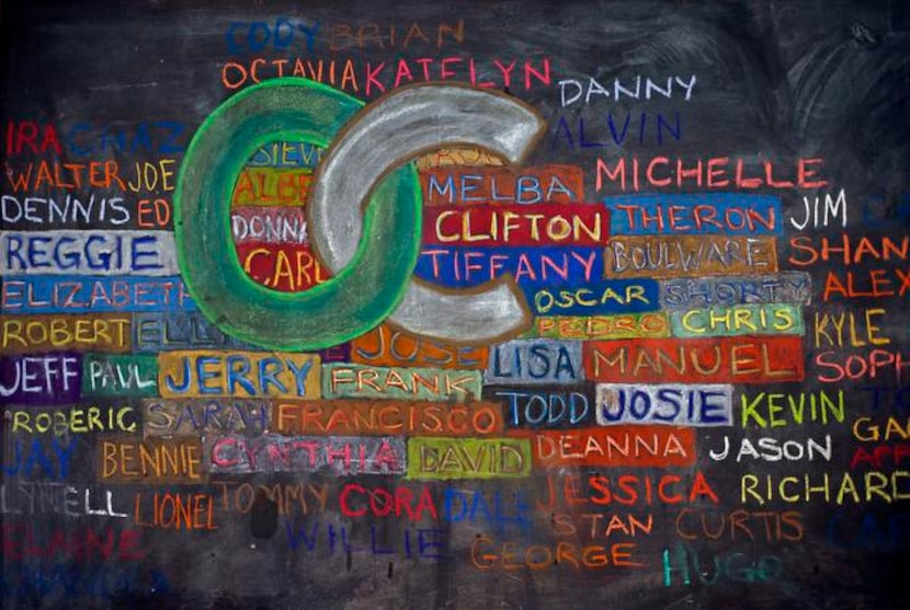 
A chalkboard on the wall at Our Calling displays art with the names of those at the...