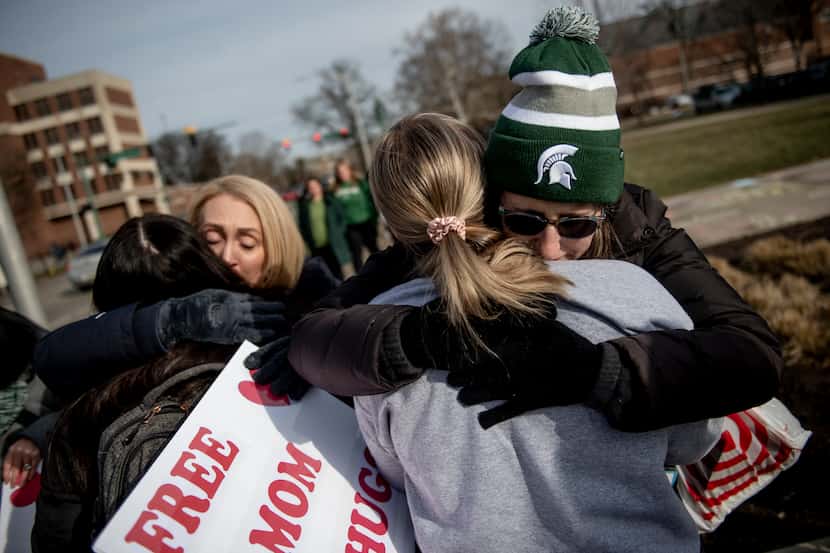 Sue Dodde, a mother from Conklin at right, embraces a student with a "free hug from a mom"...
