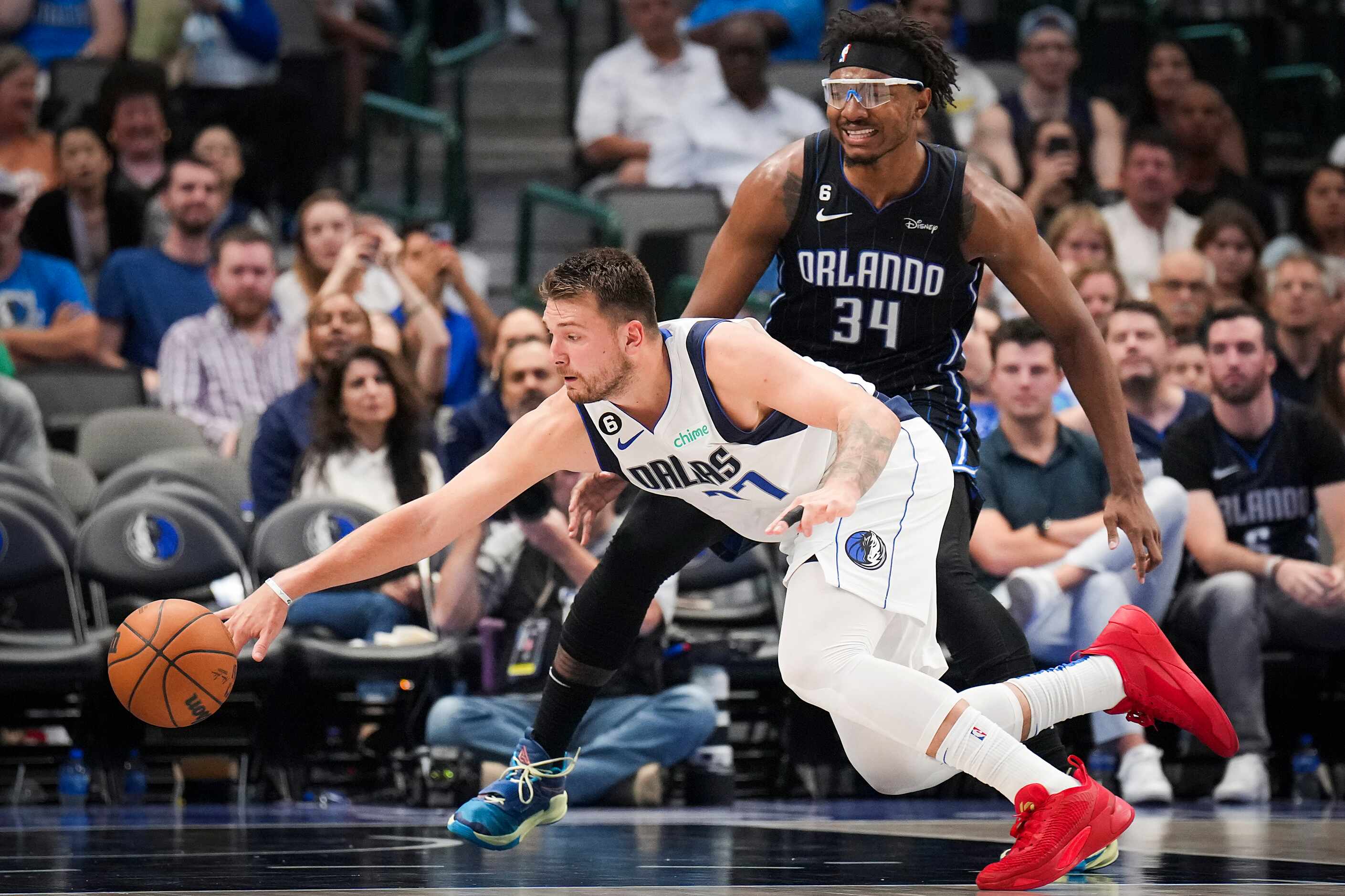 Dallas Mavericks guard Luka Doncic (77) reaches for a loose ball against Orlando Magic...