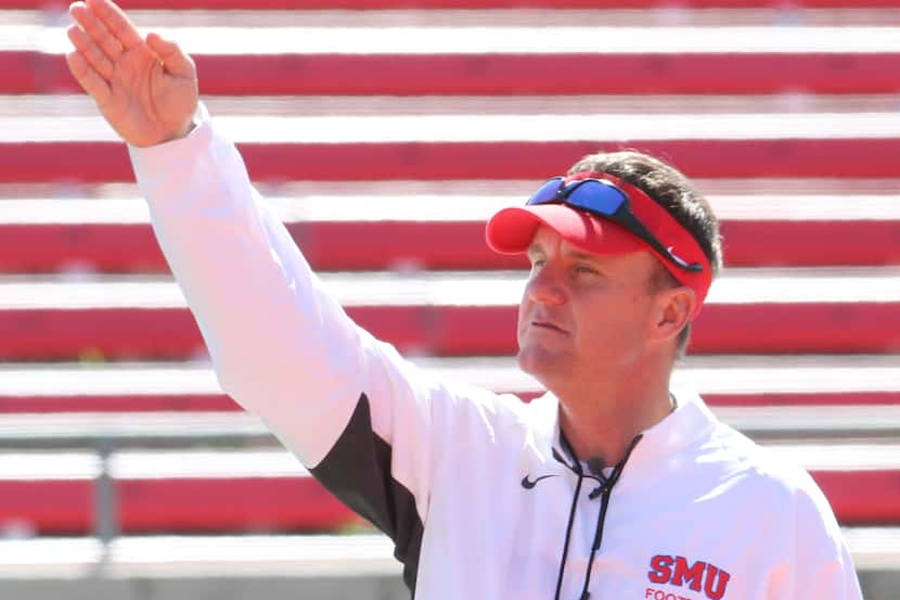 Chad Morris, new head football coach for the SMU Mustangs, gestures to players during a full...