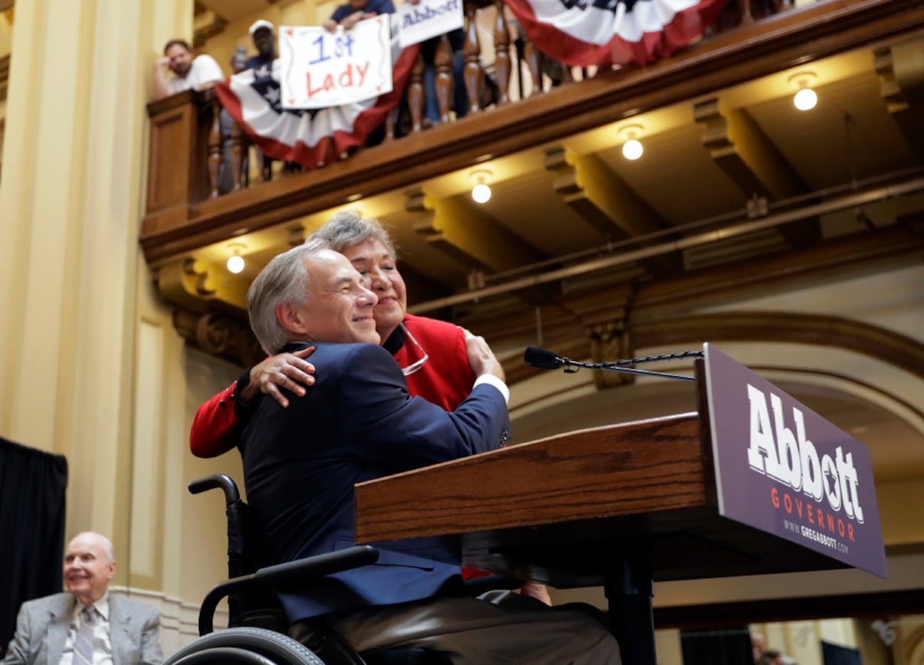 Texas Gov. Greg Abbott is hugged by his mother-in-law, Maria de la luz Segura Phalen, right,...