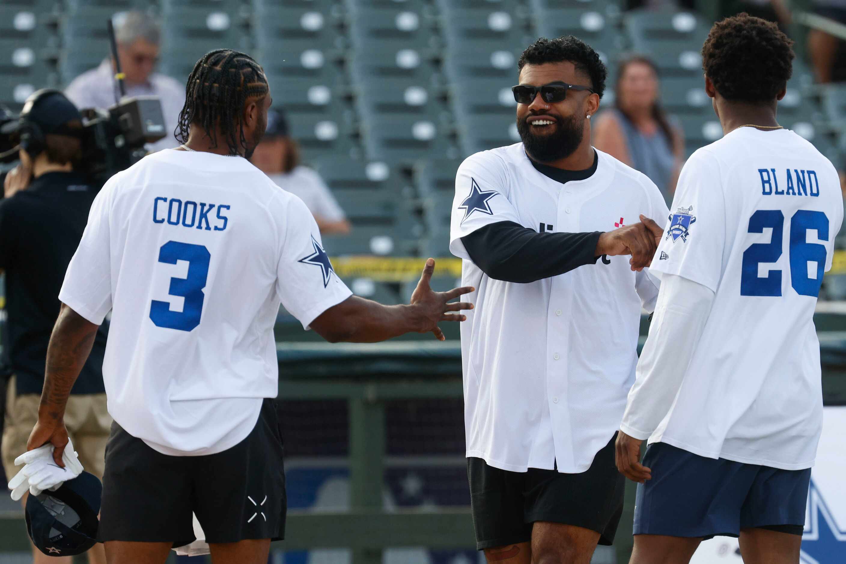 Dallas Cowboys running back Ezekiel Elliott (back) shakes hand with players upon his...