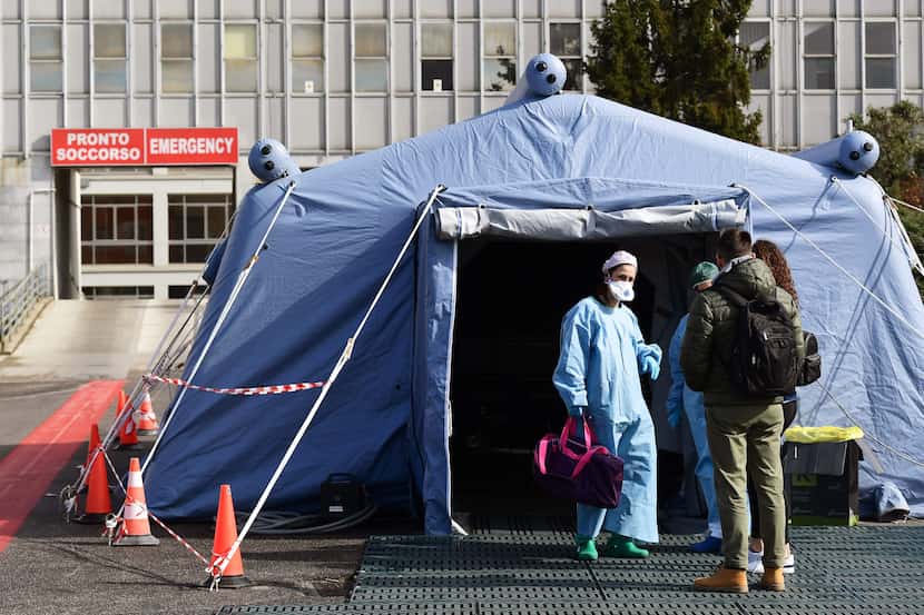People arrive at a pre-triage medical tent in front of a hospital in Cremona, Italy, on...