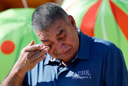 Custodian Lucino Perez wipes away tears after being presented with a Chevrolet Traverse at...