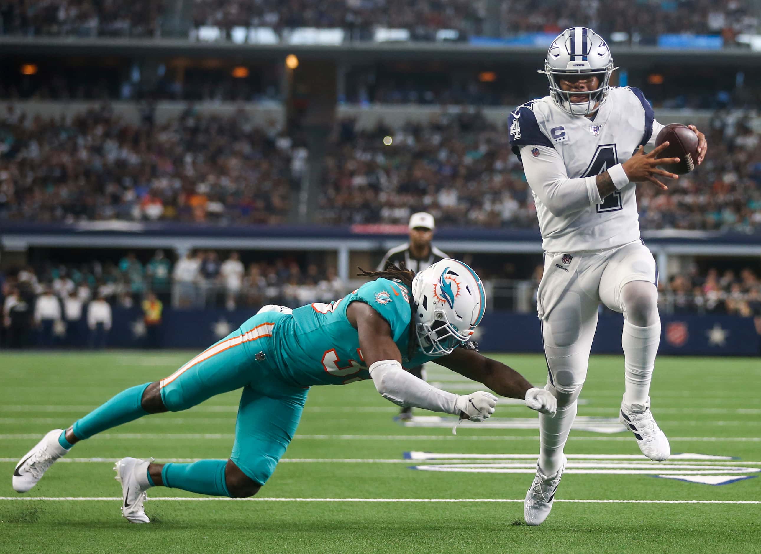 Dallas Cowboys quarterback Dak Prescott (4) carries the ball past Miami Dolphins defensive...