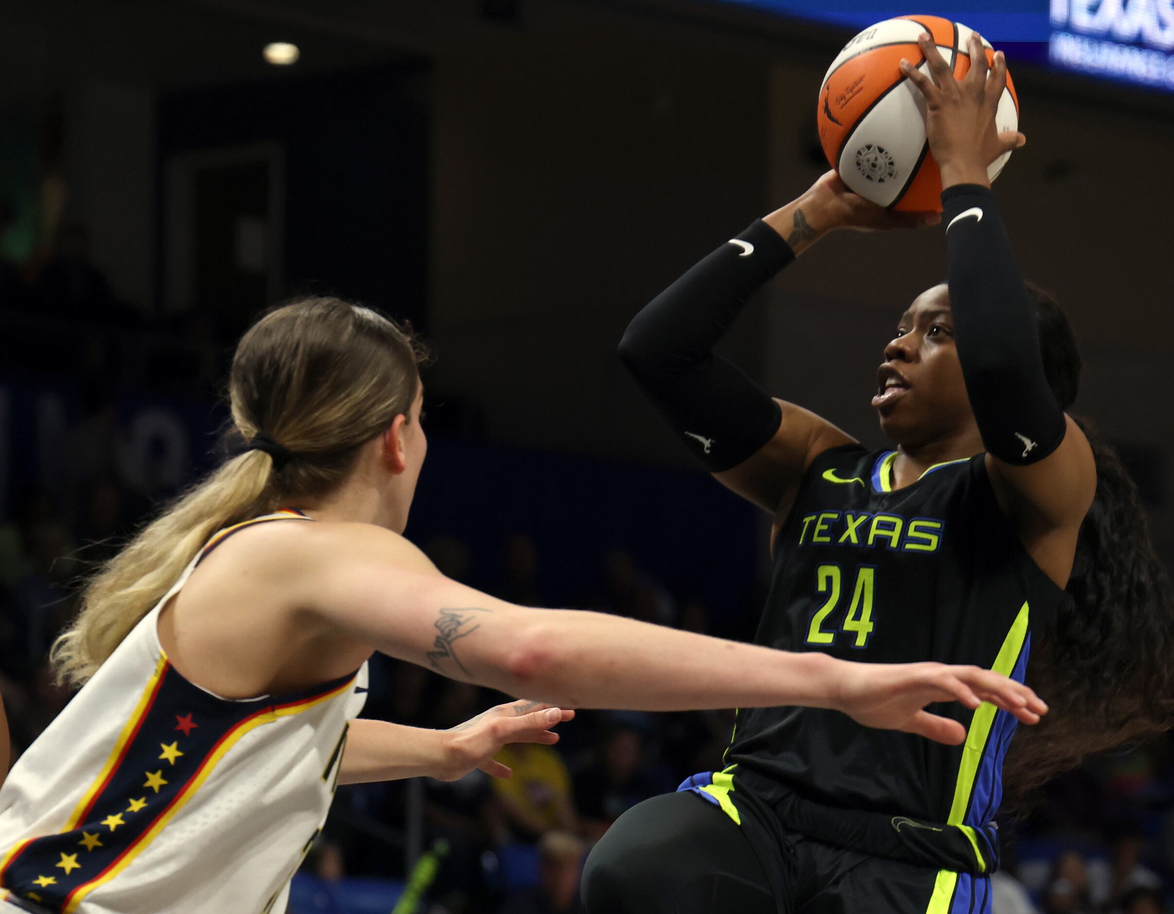 Dallas Wings guard Arike Ogunbowale (24) shoots over the defense of Indiana Fever forward...