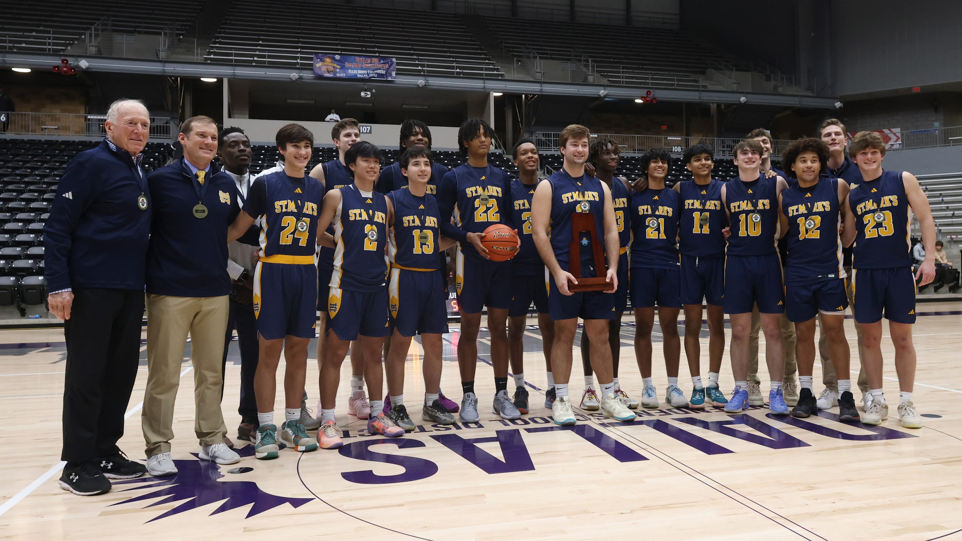 St. Mark's players and coaches pose for a team photo with their championship trophy...