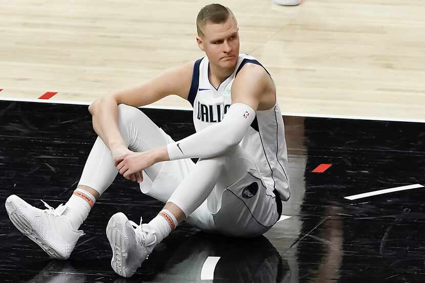 Dallas Mavericks center Kristaps Porzingis sits on the court after a foul during the second...