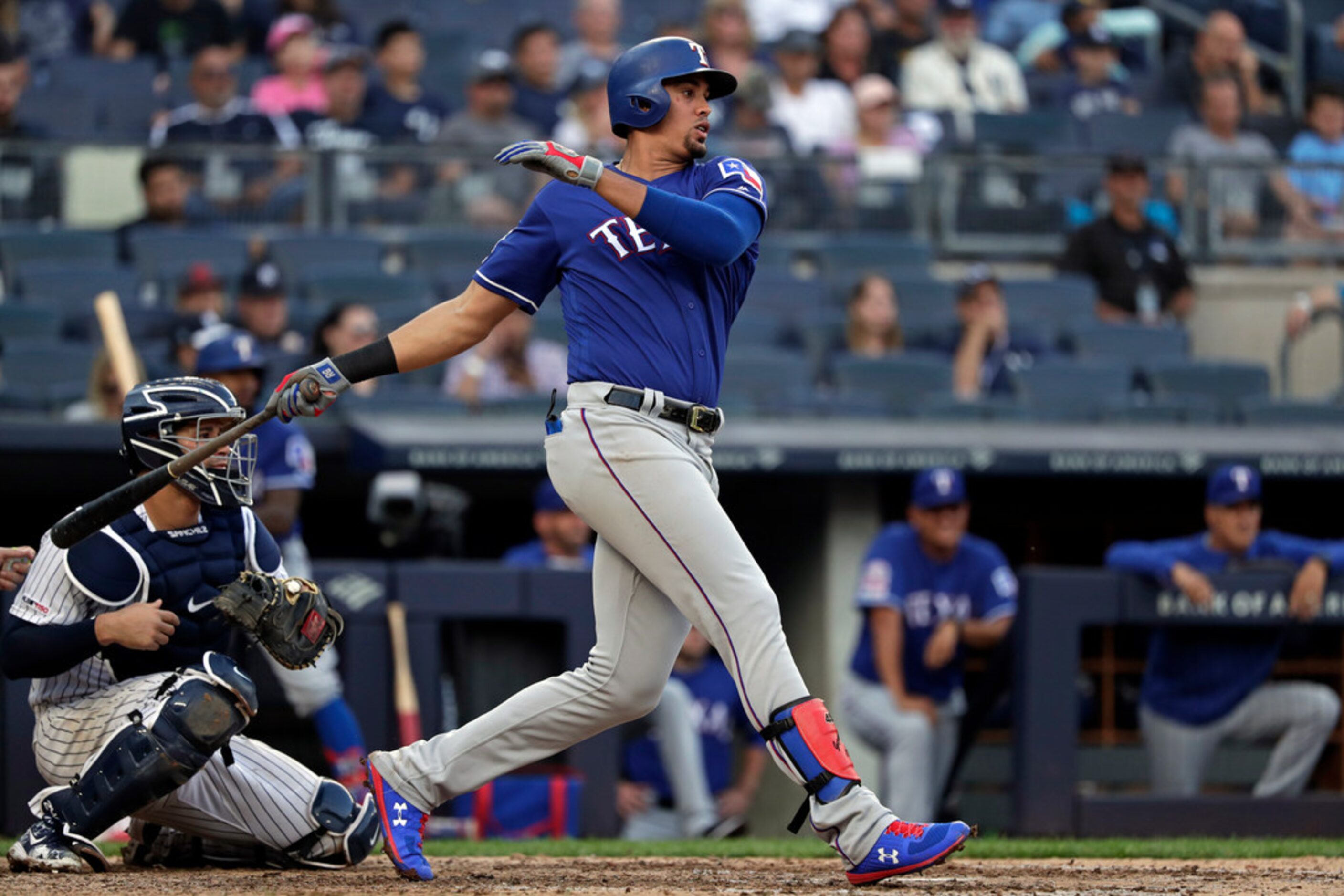 Texas Rangers' Ronald Guzman, right, watches his RBI-single during the eighth inning of a...