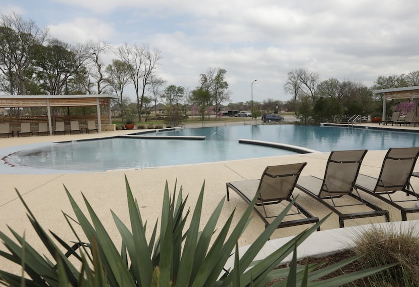 The Trinity Falls community of new homes includes a pool and lounging area.