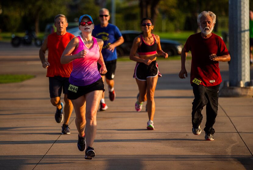 Amie Goins (044) is cheered on by her fellow runners who had just completed their runs, as...