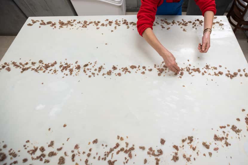 Cook Edija Halilovic spreads crumbles of ground beef as she makes a beef pita inside Eddie's...