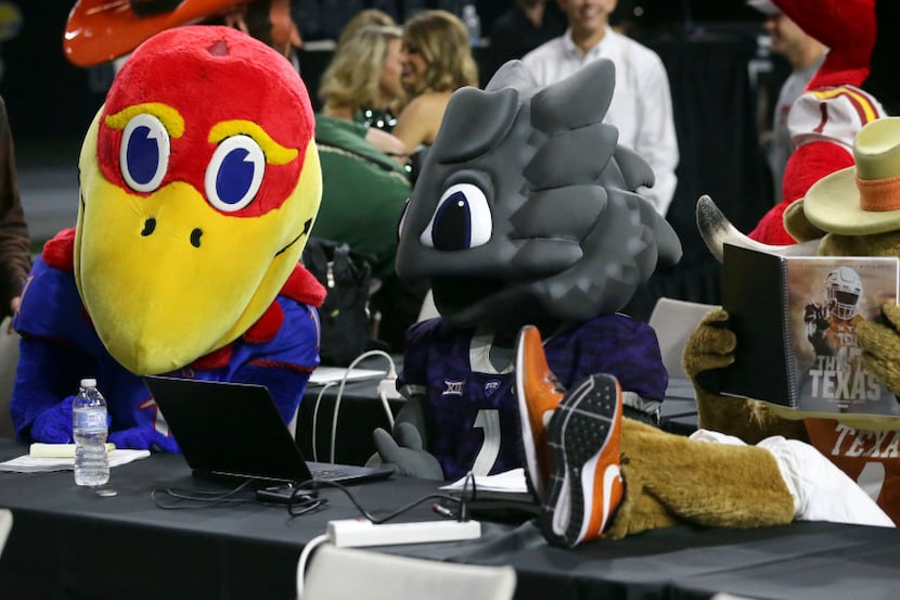 Team mascots for Kansas, TCU and Texas, from left, sit at desks for reporters before the...