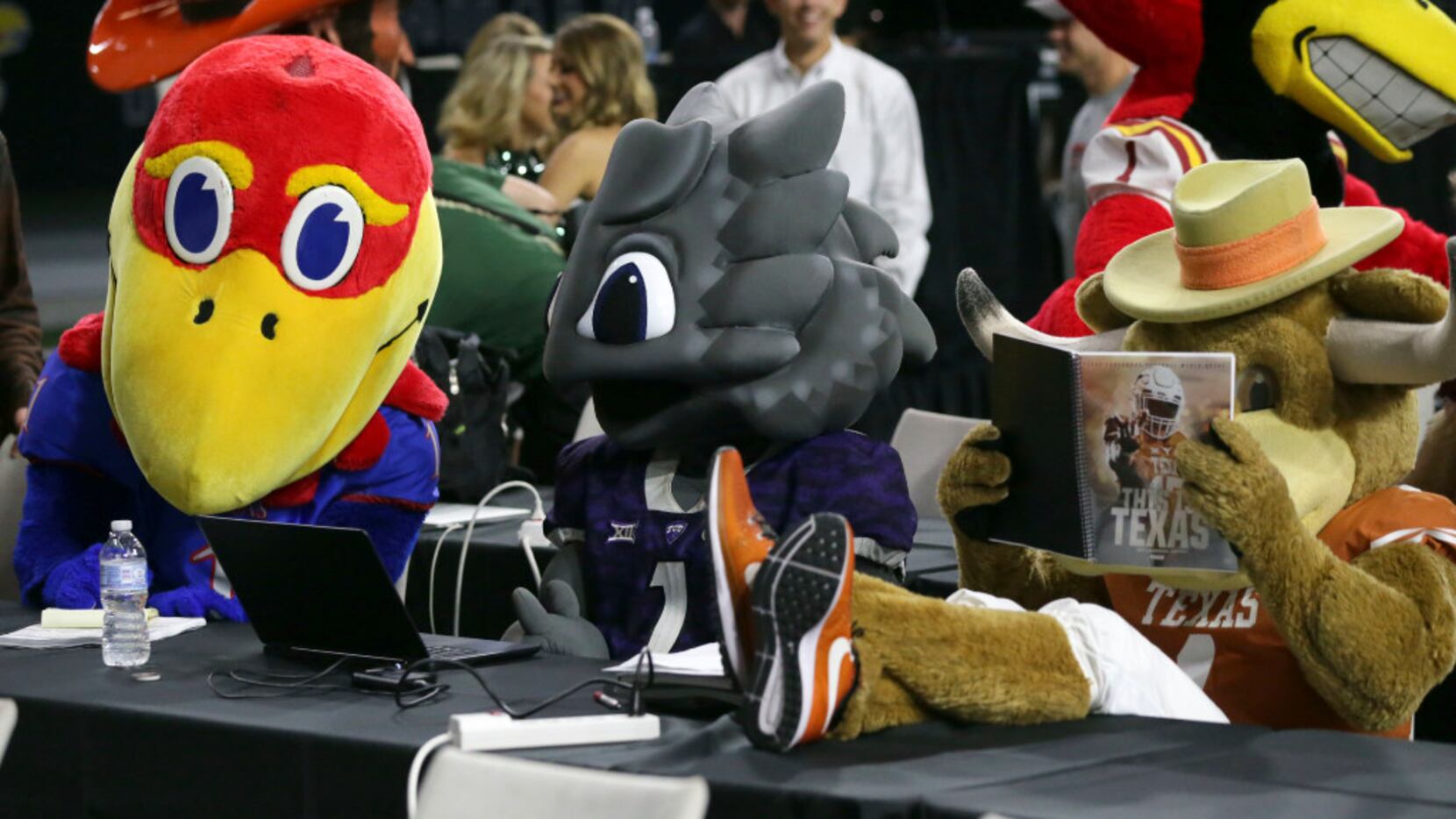 Team mascots for Kansas, TCU and Texas, from left, sit at desks for reporters before the...