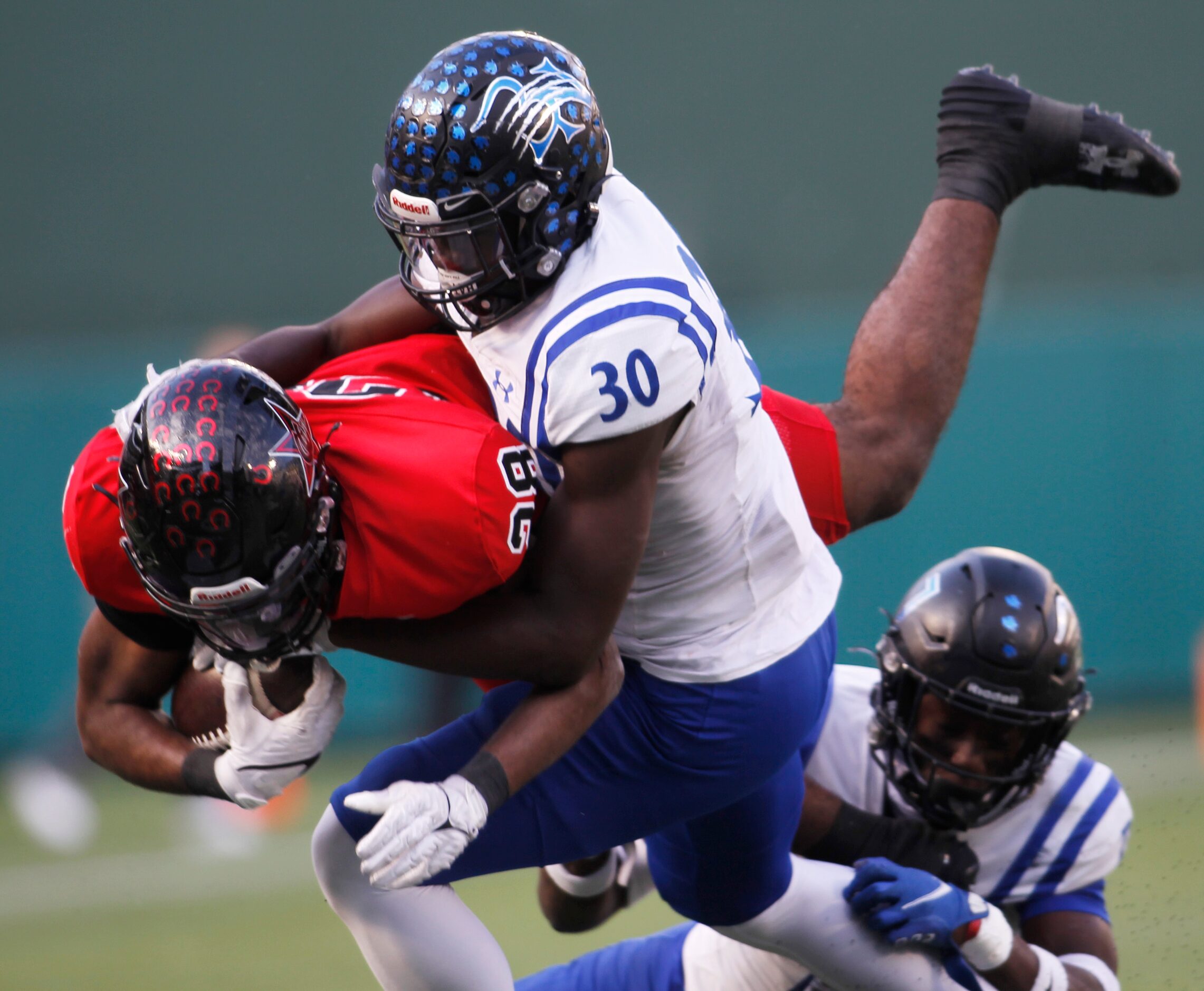 Coppell running back Xavier Mosely (28), dives for extra yardage as he is tackled by Byron...