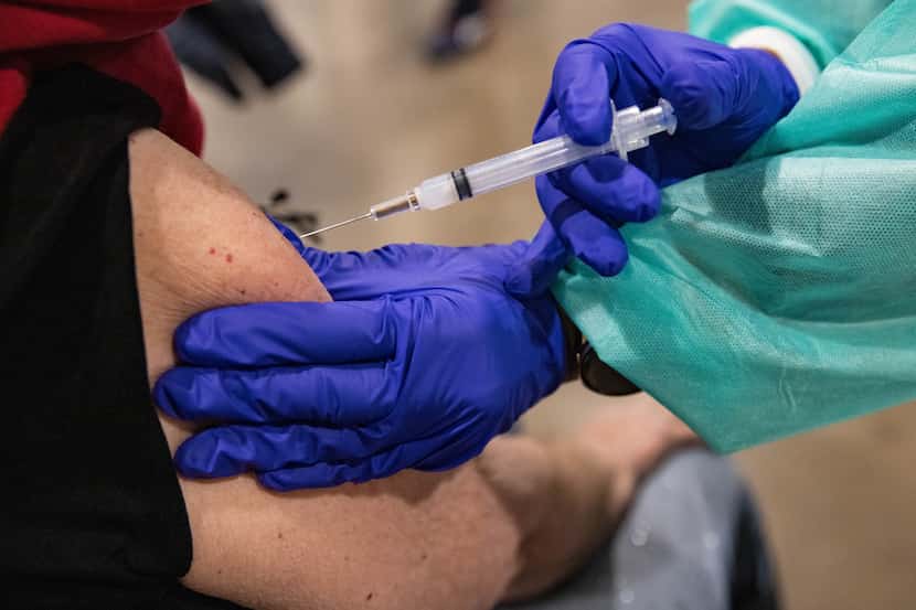 Aquila Willis injects Joy O'Leary, 79, with the COVID-19 vaccine at Fair Park in Dallas on...