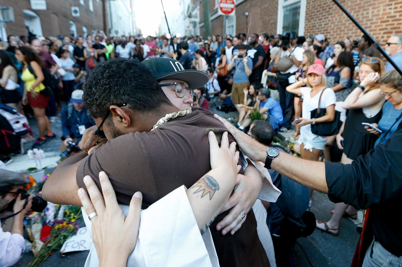 Brittney Cain-Conley (in a hat), lead organizer for Congregate Charlottesville, gets a hug...