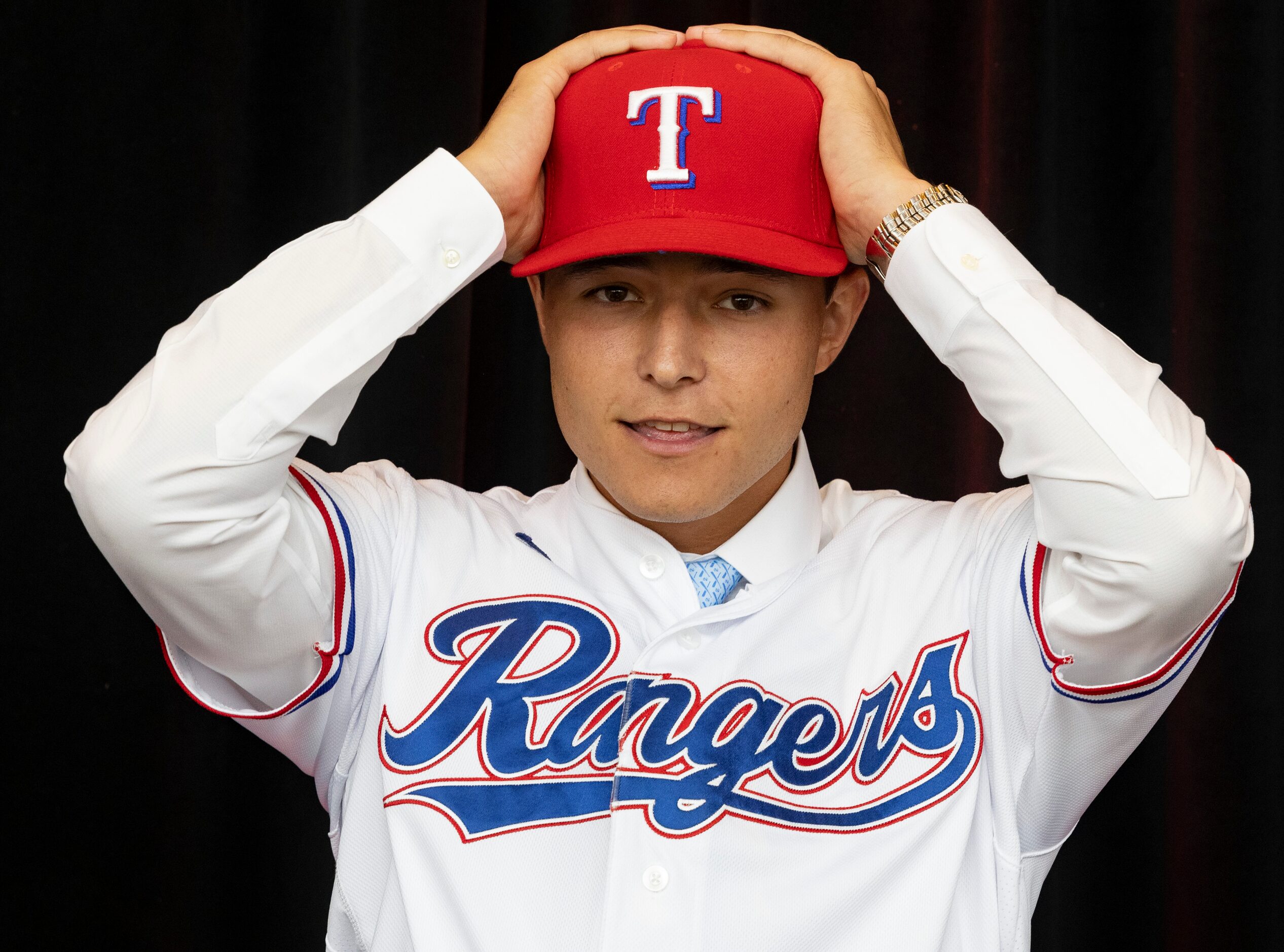 Right-handed pitcher Jack Leiter from Vanderbilt University puts on his Texas Rangers hat...